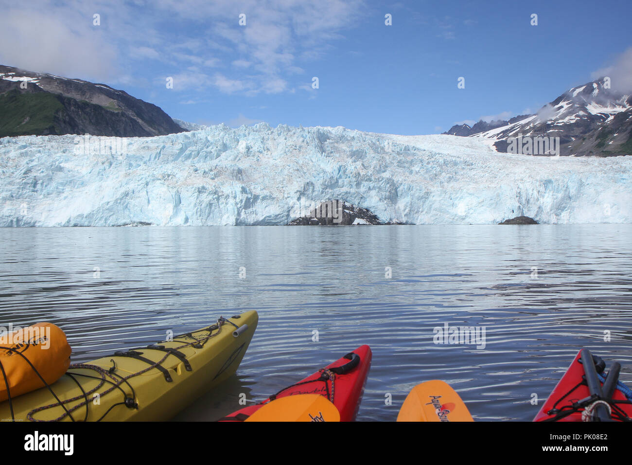 Suggerimenti di kayak in acqua nella parte anteriore del ghiacciaio Aialik, Aialik Bay, Alaska, Stati Uniti d'America. Suggerimenti di kayak in primo piano, ghiacciaio in background. Foto Stock