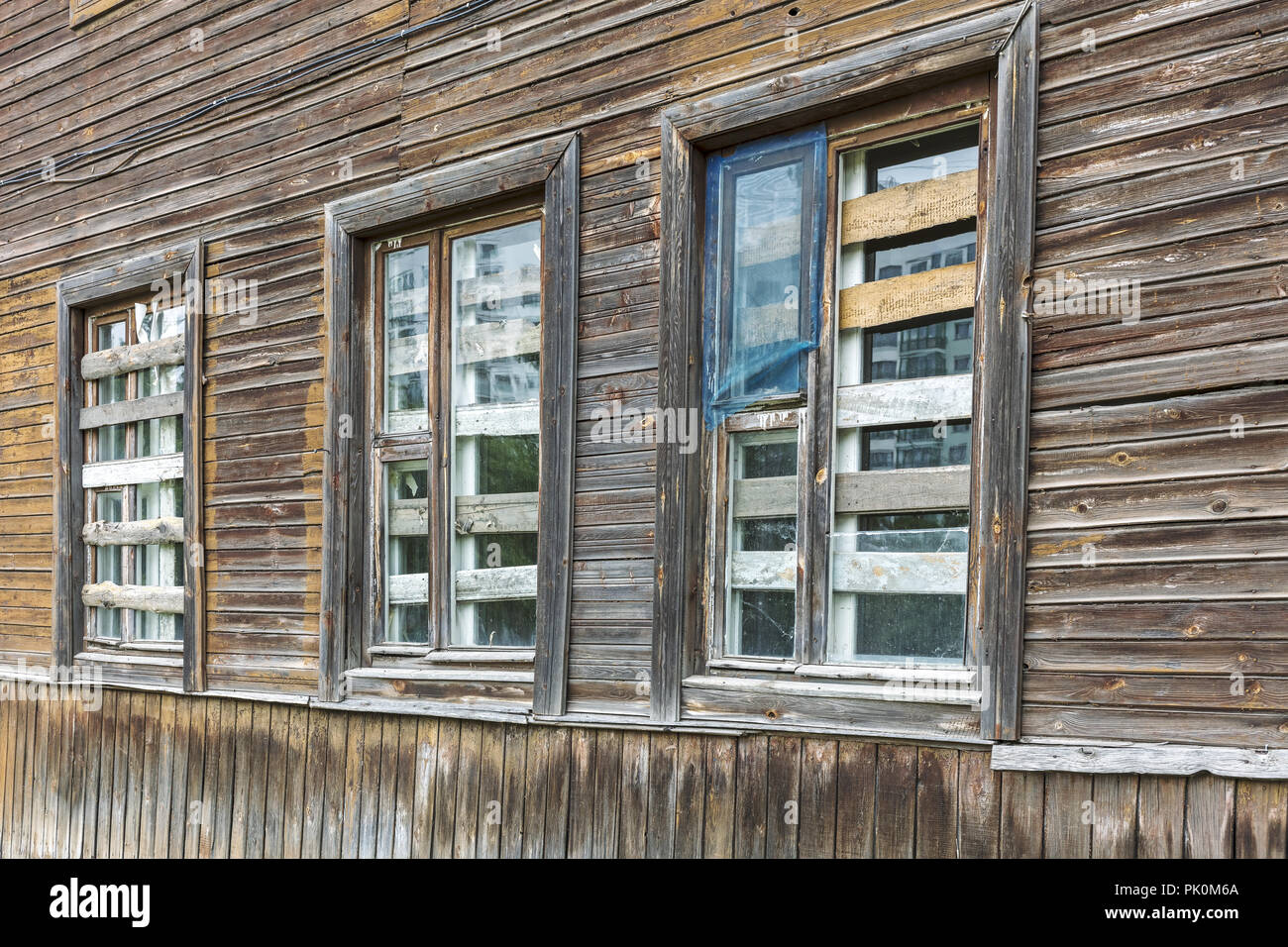 Tre sono saliti di Windows di un vecchio abbandonato fatiscente costruzione in legno Foto Stock