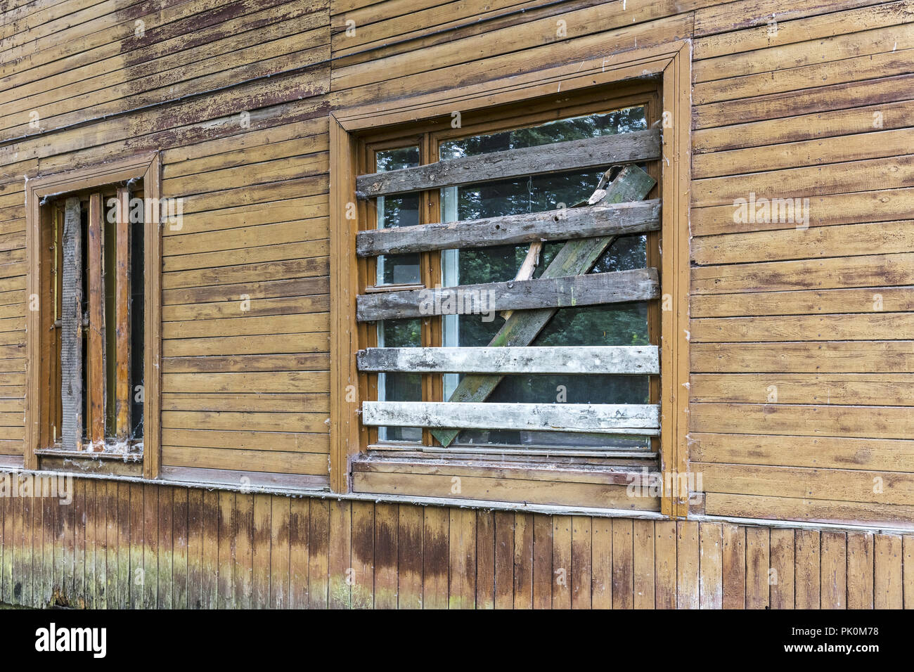 Parete del vecchio fatiscente costruzione in legno con imbarcati su windows Foto Stock