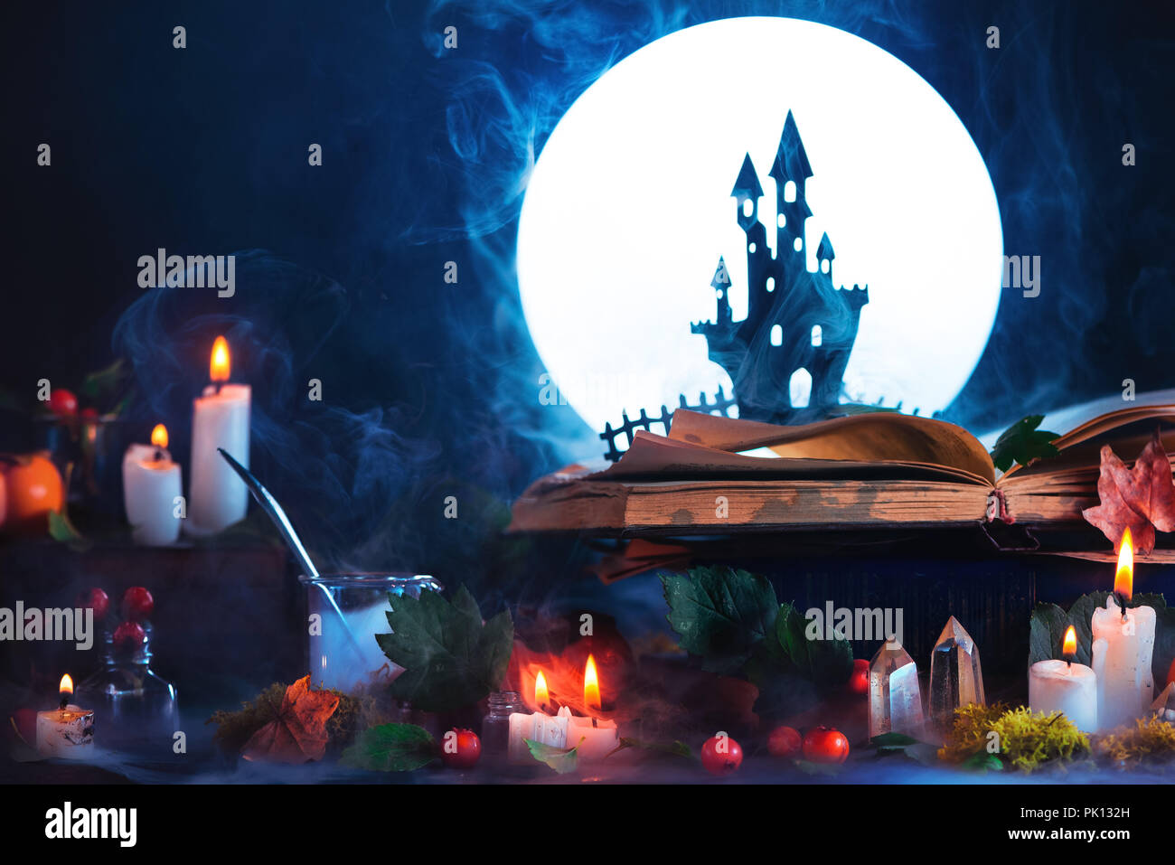 Concetto di Halloween con un haunted castle silhouette di fronte la luna piena. Libro di incantesimi su strega o una procedura guidata sul luogo di lavoro. Magica creativa ancora in vita su Foto Stock