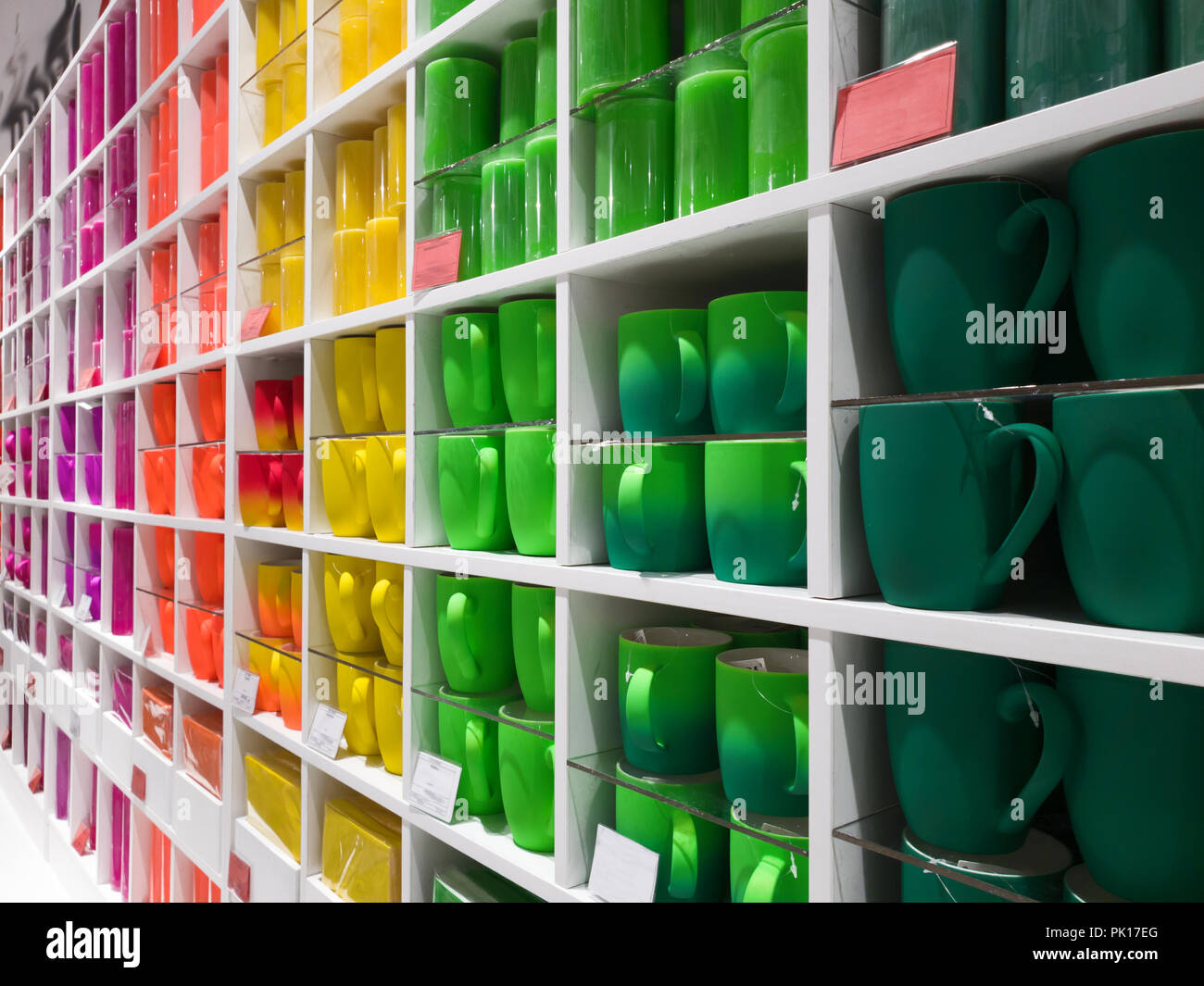Tazze di colori diversi stand nella vetrina del negozio Foto Stock