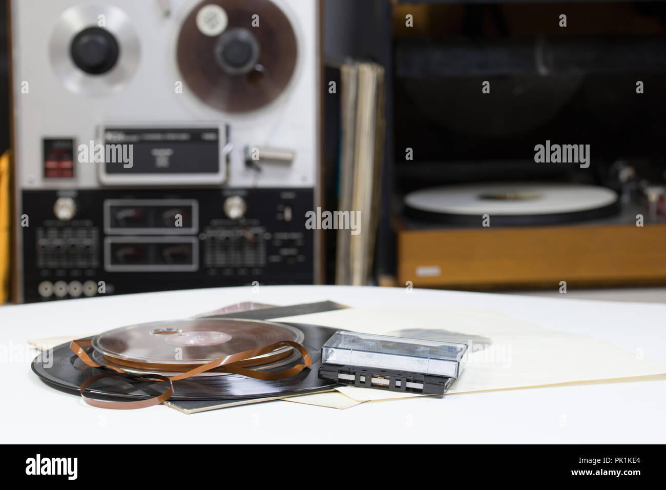 Dischi in Vinile con copia spazio nella parte anteriore di una raccolta di album titoli fittizia, processo vintage. Analog aspo registratore a nastro. Audio cassetes toccare. Foto Stock