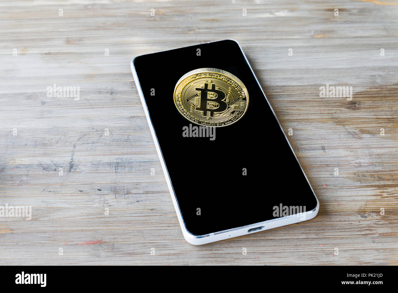 Un Bitcoin Cryptocurrency Bit digitale medaglia BTC valuta la tecnologia Internet Business concetto. Bitcoin su smartphone Foto Stock