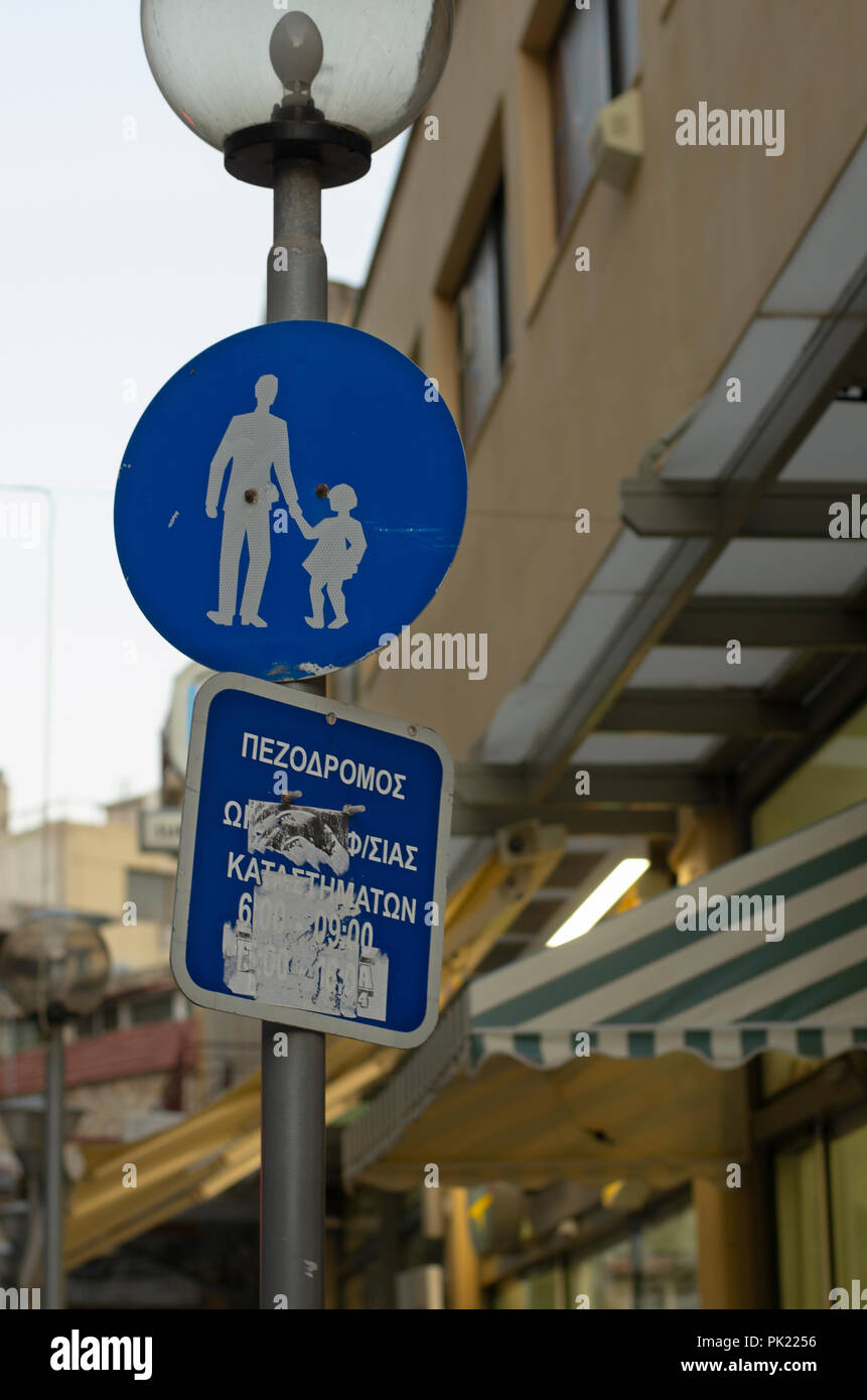 Round cartello stradale "Attenzione bambini' e iscrizione greca circa il parcheggio pubblico (senza marchio) in Grecia Foto Stock
