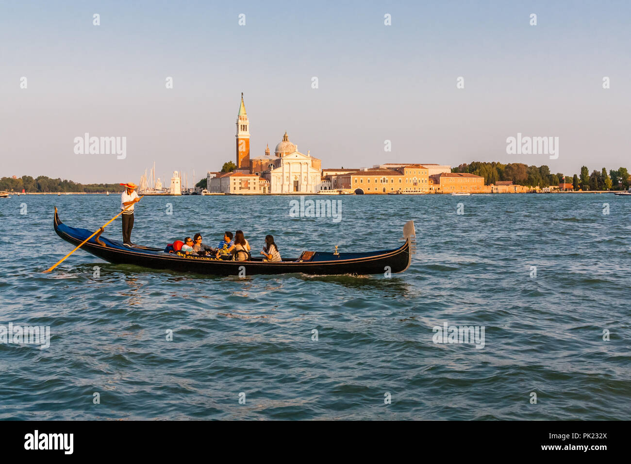 I turisti in una gondola, di fronte al Palazzo dei Dogi e St Marks Chiesa, Venezia, Italia nella luce della sera. Foto Stock