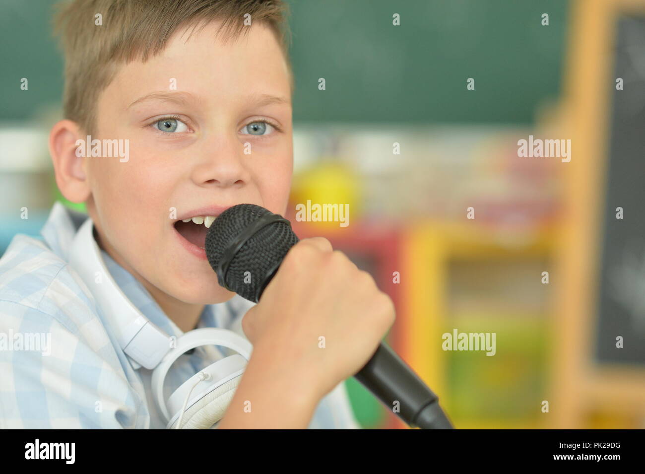 Ritratto di ragazzo cantando il karaoke a casa Foto Stock