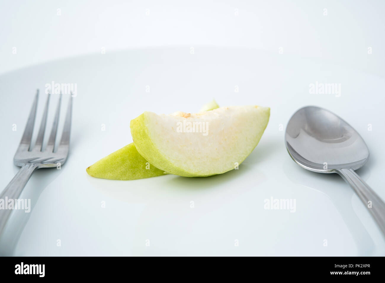 La salute di mangiare del frutto guava sulla piastra bianca con cucchiaio e forchetta Foto Stock