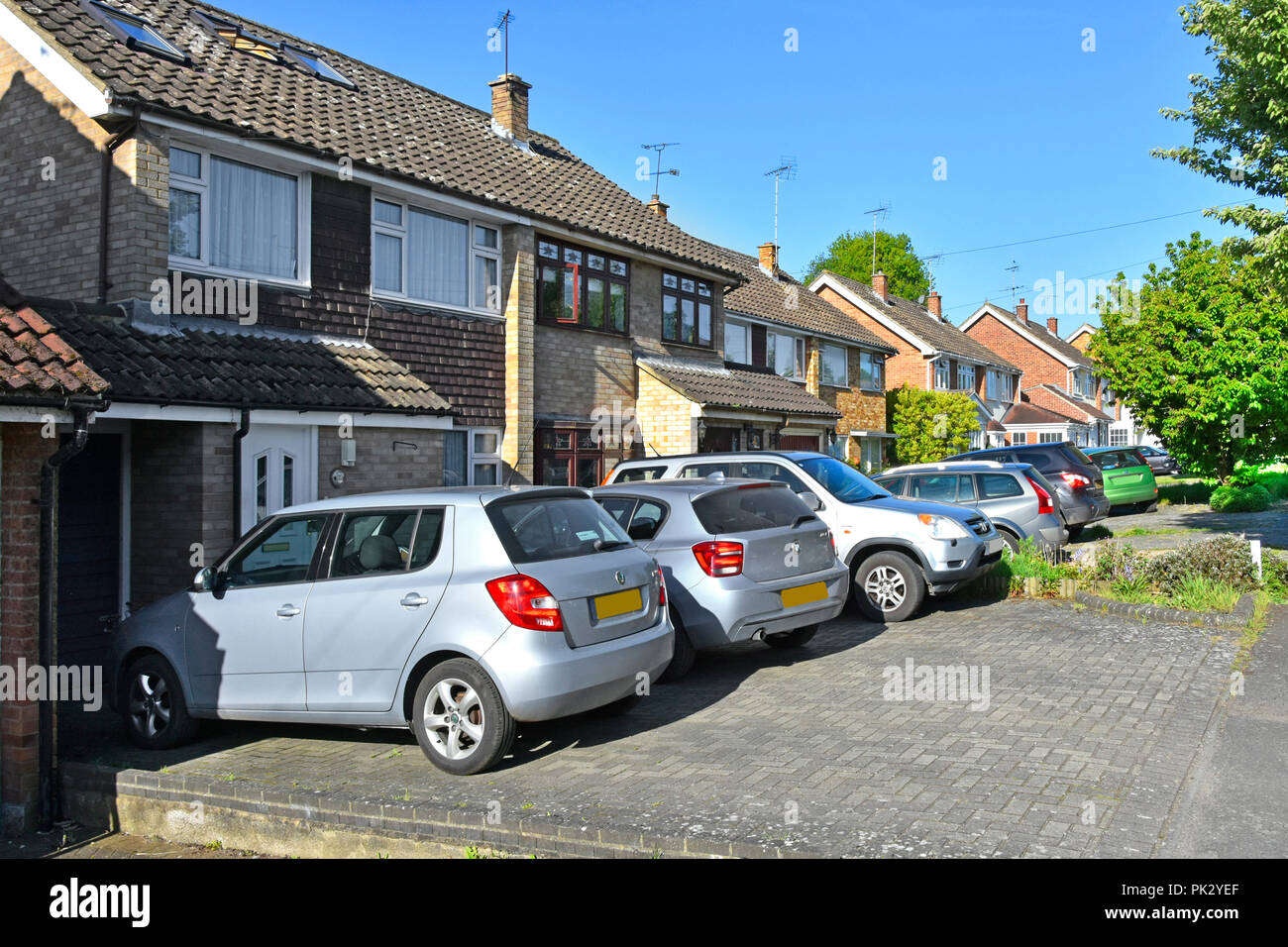 Sobborgo street scene row case semi staccate su pavimentazione giardino frontale con vialetto pavimentato sostituzione house prato per spazio parcheggio per auto Essex England Regno Unito Foto Stock
