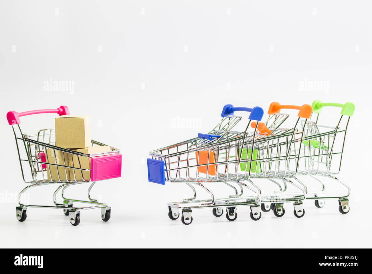 Concetti di shopping: scatole di cartone mettere la merce ordinata dal cliente in rosa carrello e molti carrello pronto per l'ordine. Foto Stock