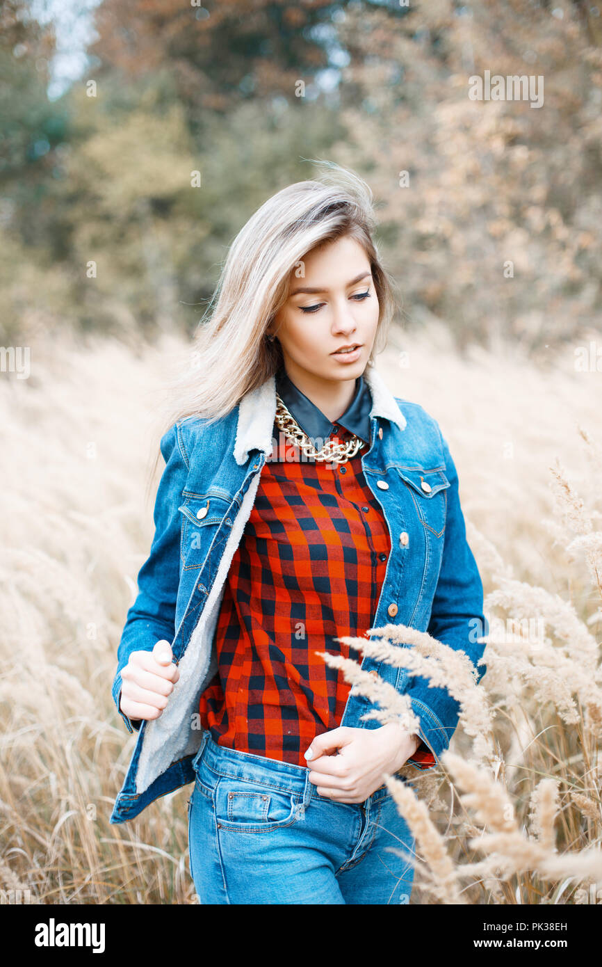 Bella ragazza elegante in camicia di denim, a scacchi maglietta rossa e blu jeans. Foto Stock