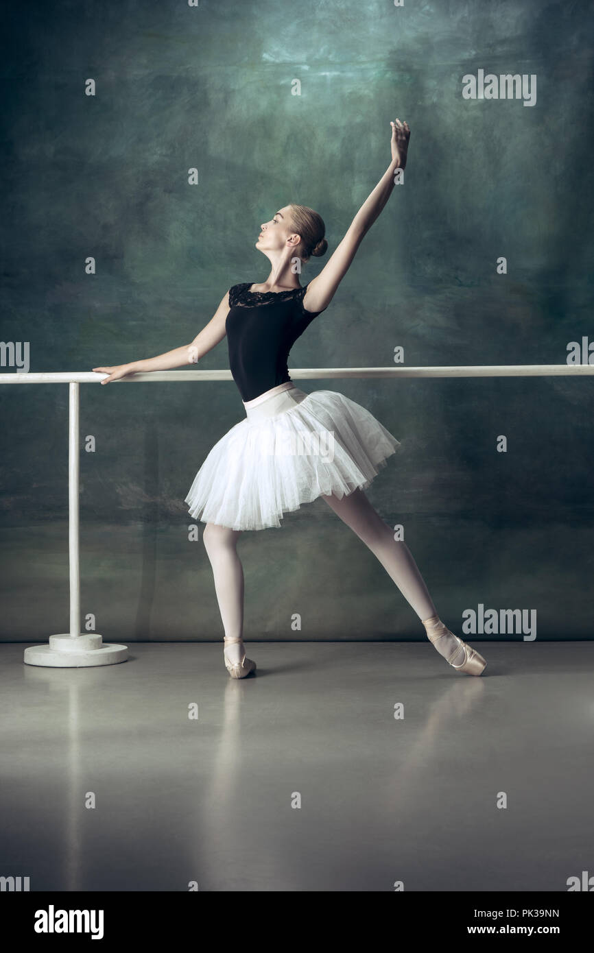 La classica ballerina in bianco tutu in posa a ballet barre su sfondo per  studio. Young Teen prima di ballare. Ballerina progetto con modello  caucasico. Il balletto, danza, arte contemporanea, coreografia di