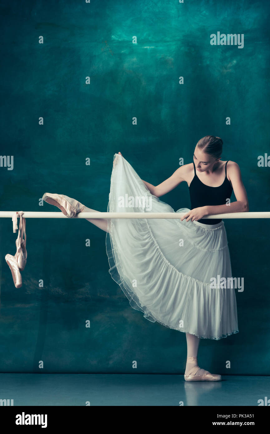 La classica ballerina in bianco tutu in posa a ballet barre su sfondo per  studio. Young Teen prima di ballare. Ballerina progetto con modello  caucasico. Il balletto, danza, arte contemporanea, coreografia di