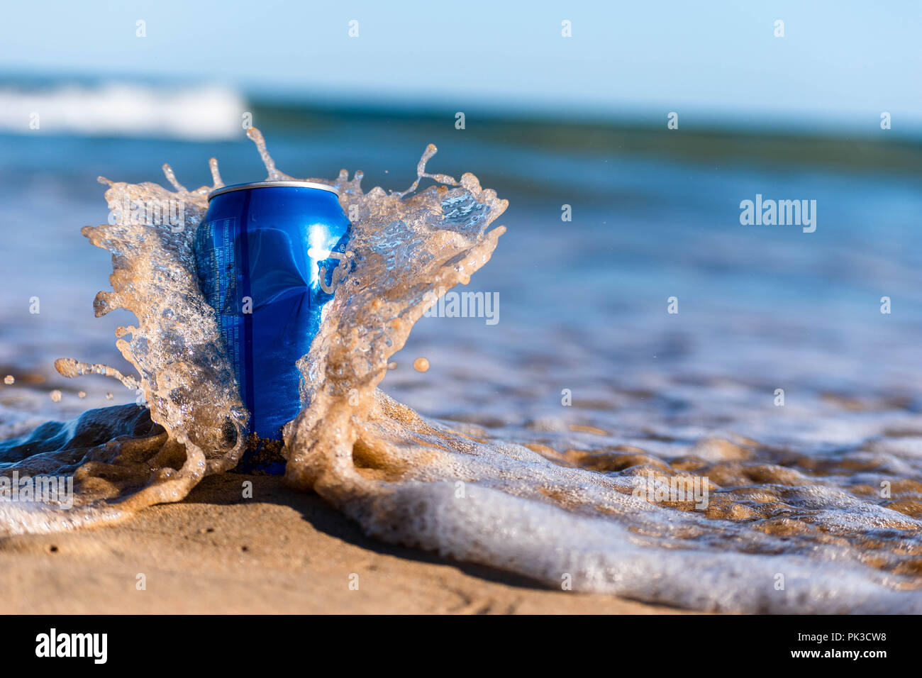 Wave coming off e spruzzi su scartato può Foto Stock