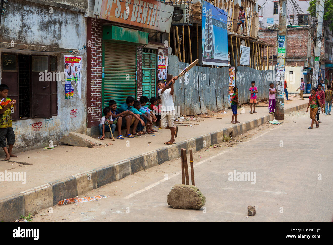 Bambini che giocano una partita di cricket di strada a Dhaka, nel Bangladesh. Foto Stock