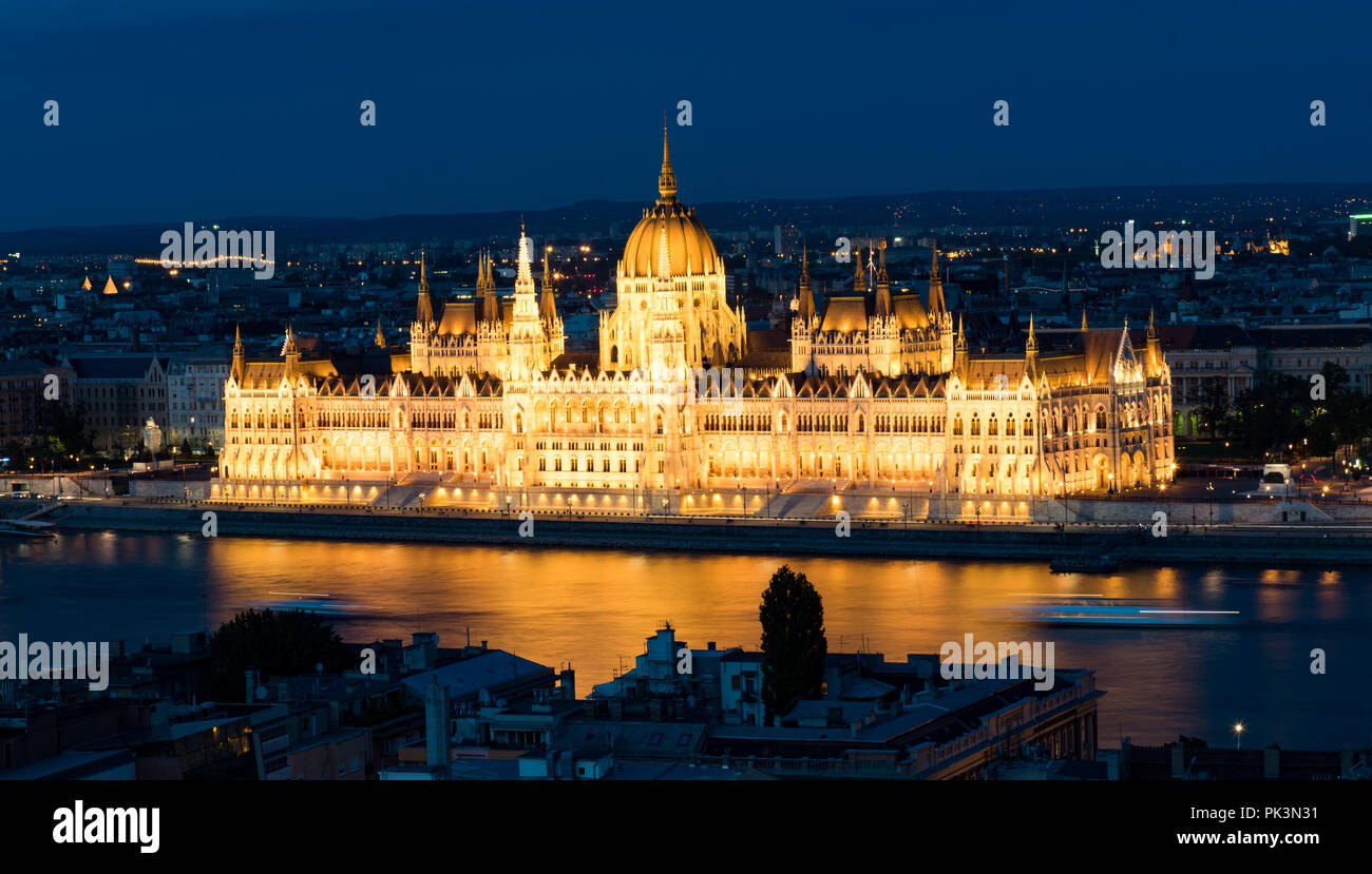Parlamento ungherese di Budapest si riflette nel fiume Danubio blu a ora Foto Stock