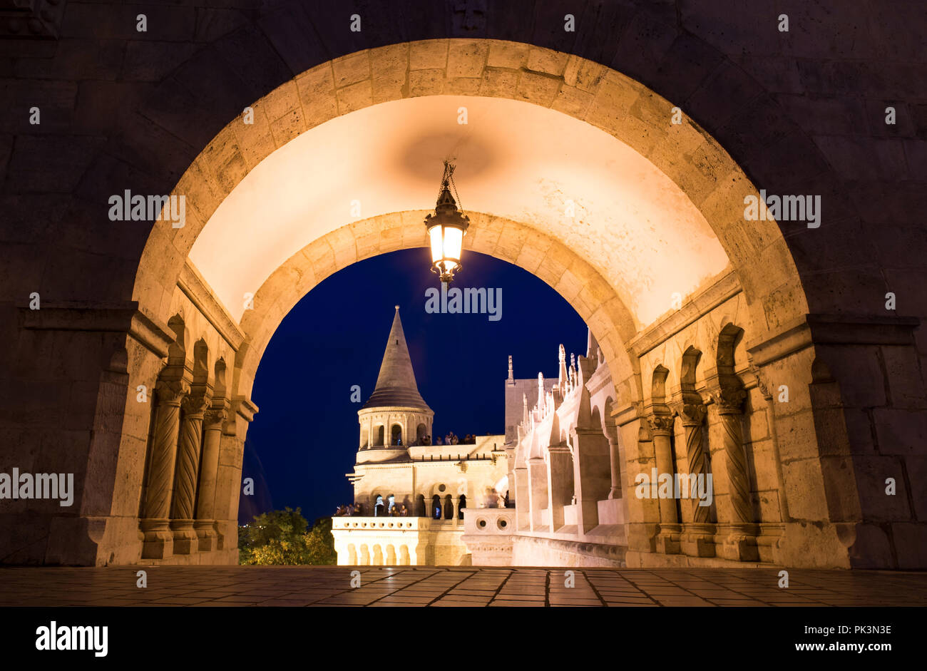 Budapest Bastione del Pescatore edificio con visite turistiche vista attraverso il cancello di notte Foto Stock
