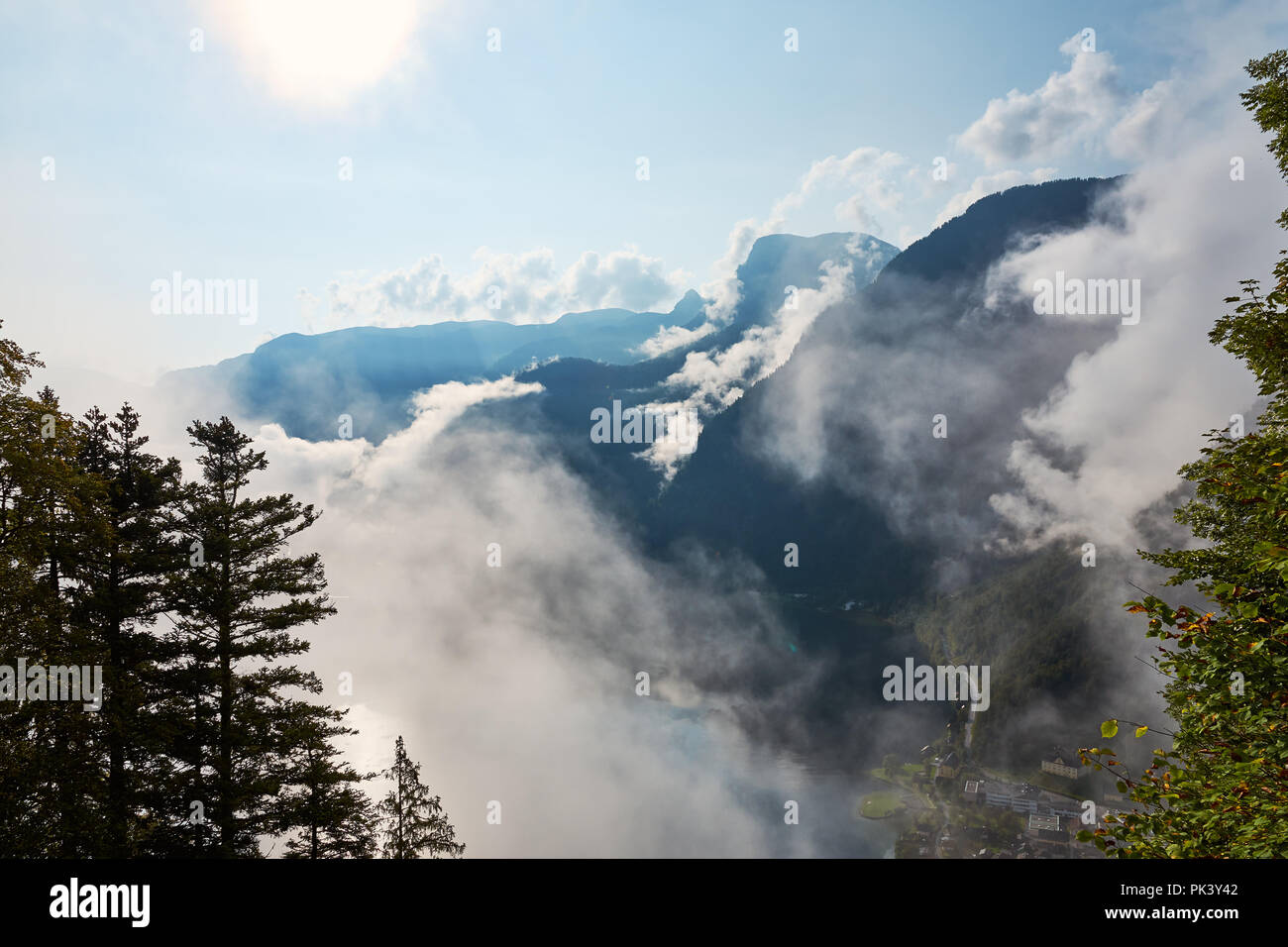 Vista sulle montagne, foreste e cielo blu con nuvole al villaggio e il lago Hallstatt in Austria Foto Stock