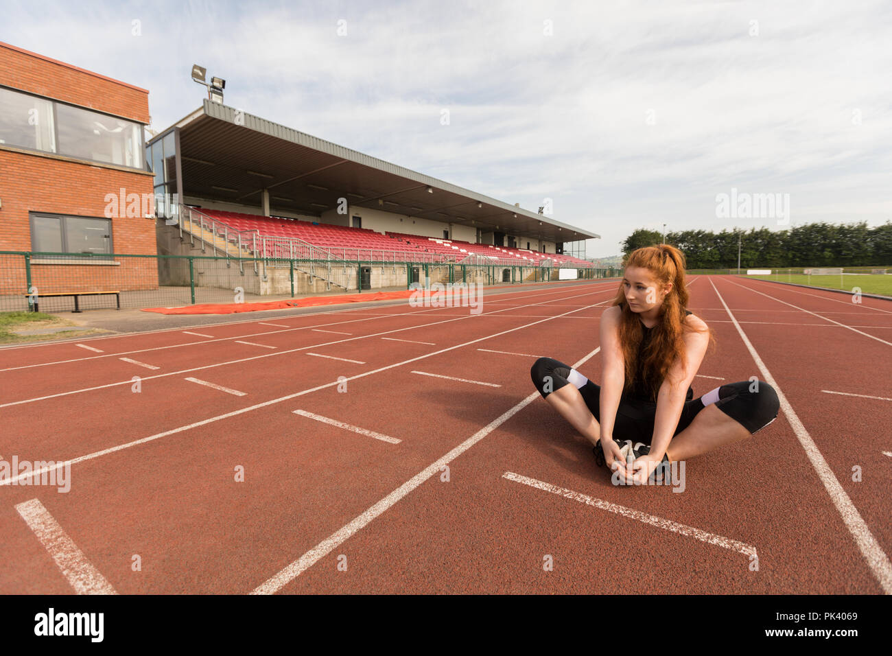 Atletica femmina esercita sulla via di corsa Foto Stock