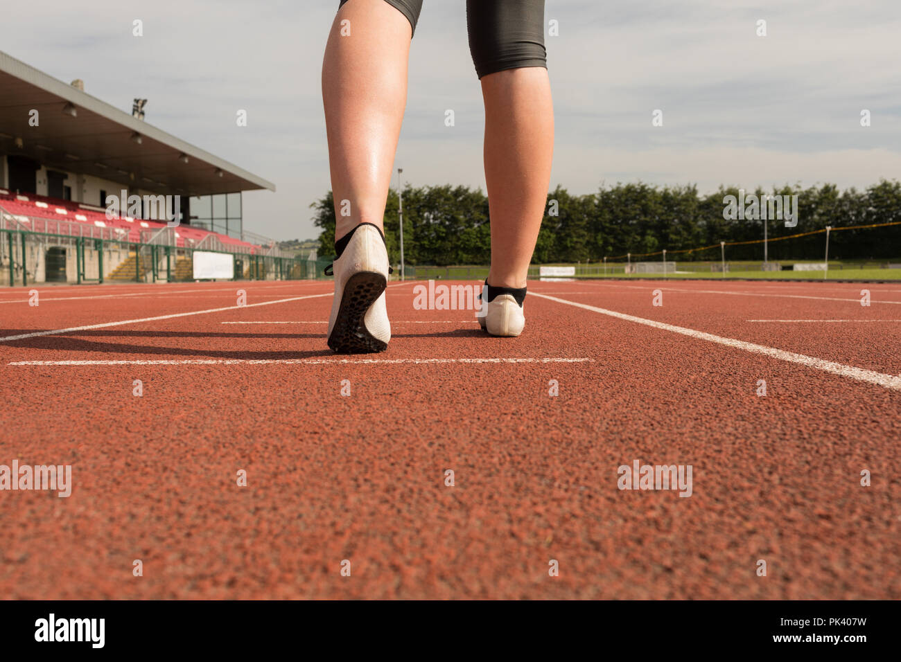 Atletica femmina permanente sulla via di corsa Foto Stock