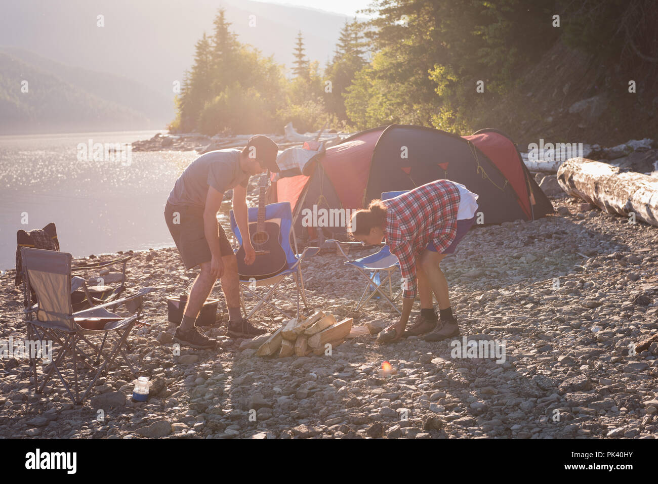 Paio di preparare il fuoco vicino a Riverside Foto Stock