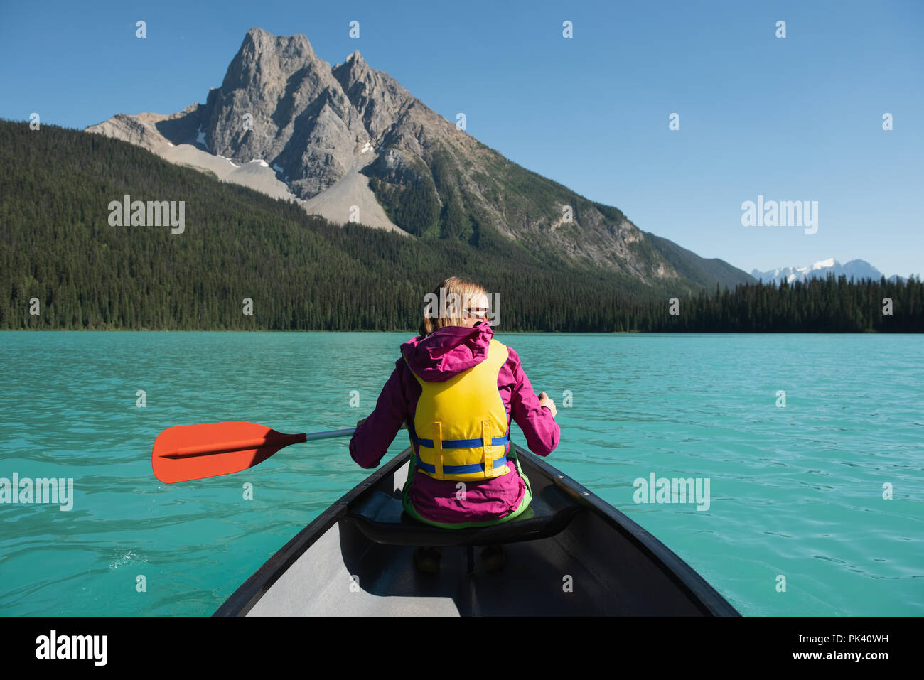 Donna in barca nel fiume in campagna Foto Stock