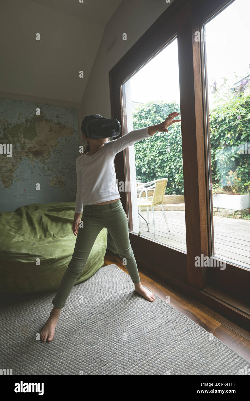 Ragazza con la realtà virtuale auricolare in salotto Foto Stock