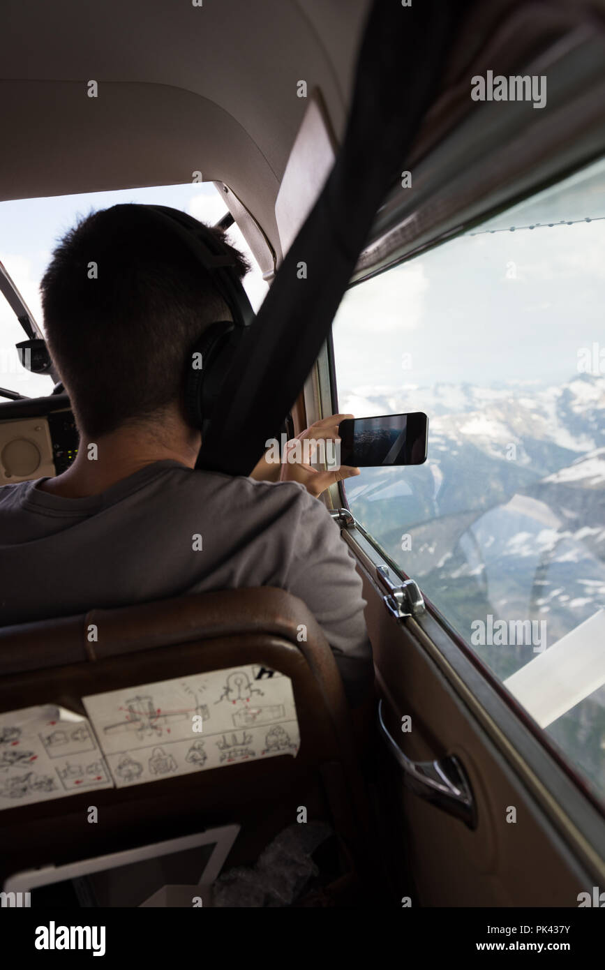 Pilota di scattare foto con il cellulare durante il volo Foto Stock