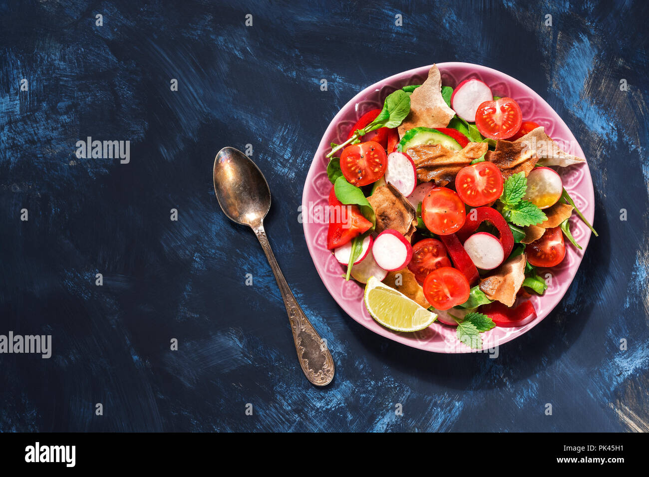 Arabo insalata di verdure fresche con pane Fattoush su uno sfondo blu. Vista superiore, copia dello spazio. Foto Stock