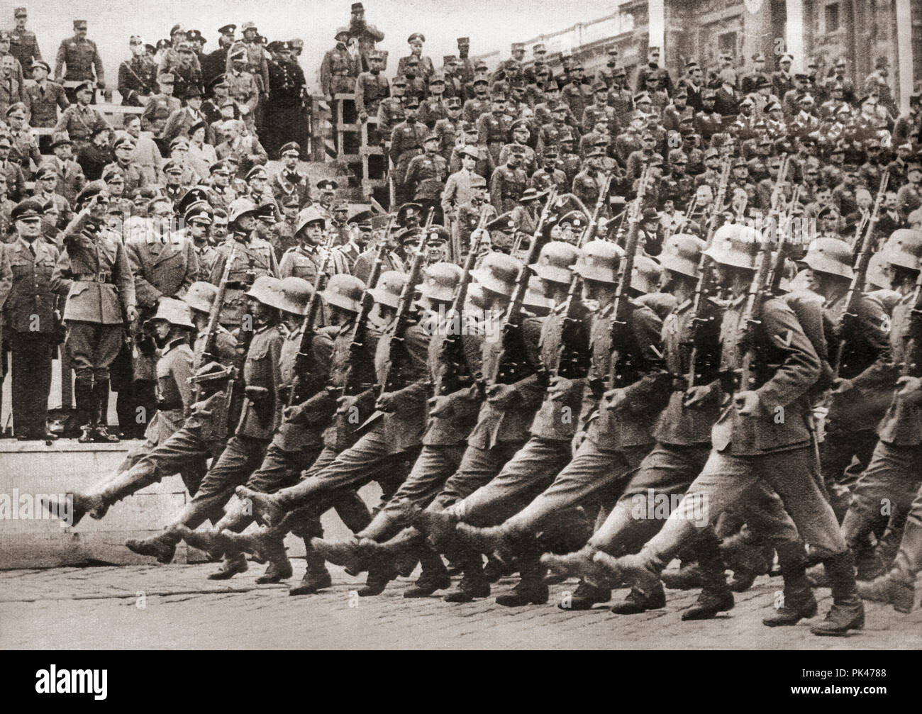 Truppe della 1° Divisione dell'VIII Armata tedesca Corps marciando in Vienna, Austria il 12 marzo 1938, per l'allegato la lingua tedesca nazione per il Terzo Reich. Da questi straordinari anni, pubblicato in 1938. Foto Stock