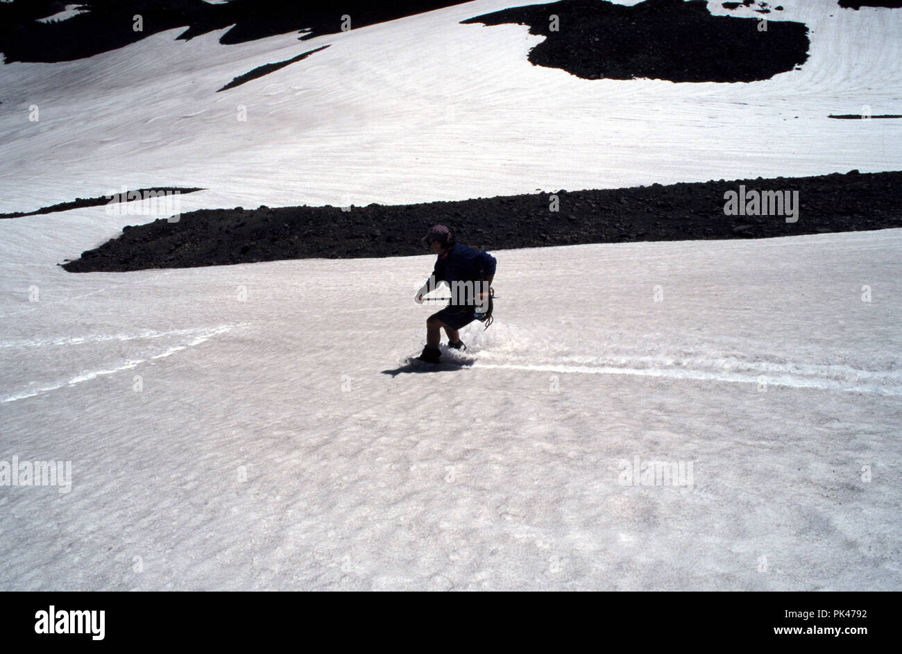 OutdoorSport40/121801 -- un alpinista glissade spento del Medio sorella in tre sorelle Wilderness Area, Oregon. Foto Stock