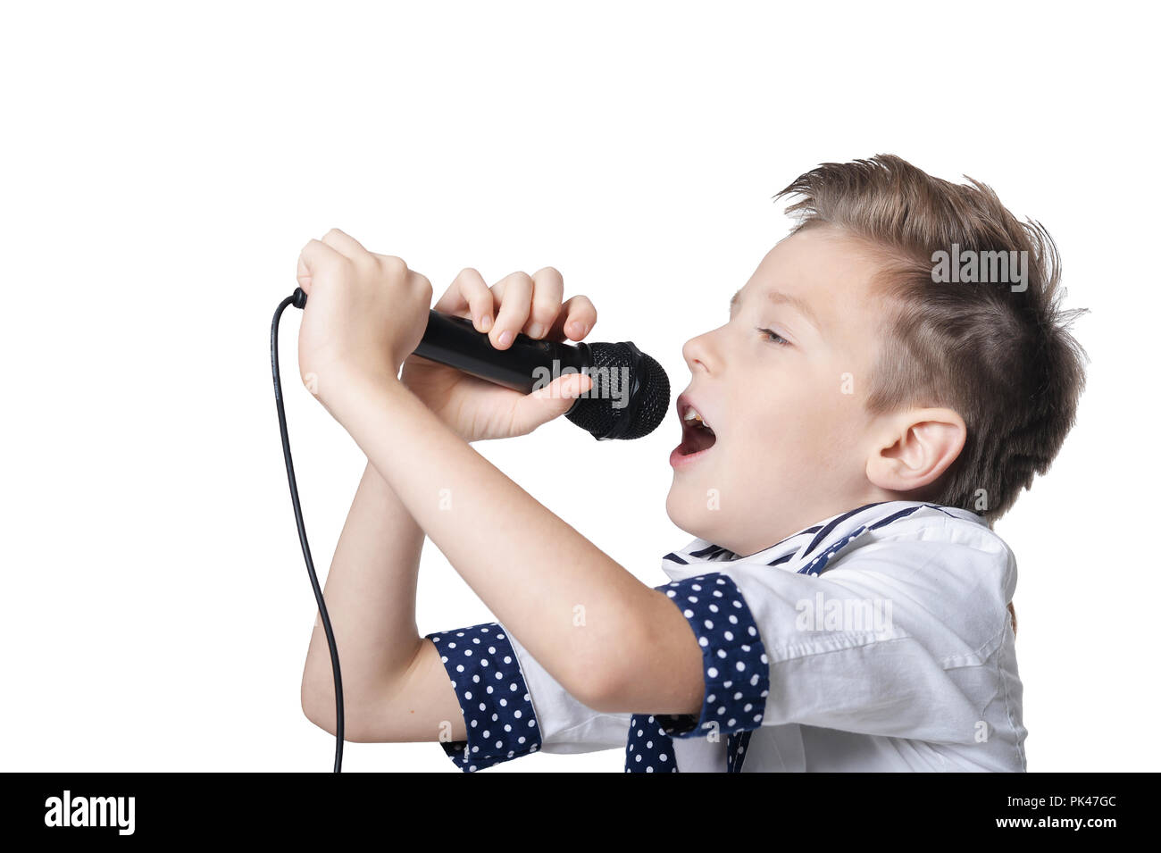 Little Boy con microfono su sfondo bianco Foto Stock