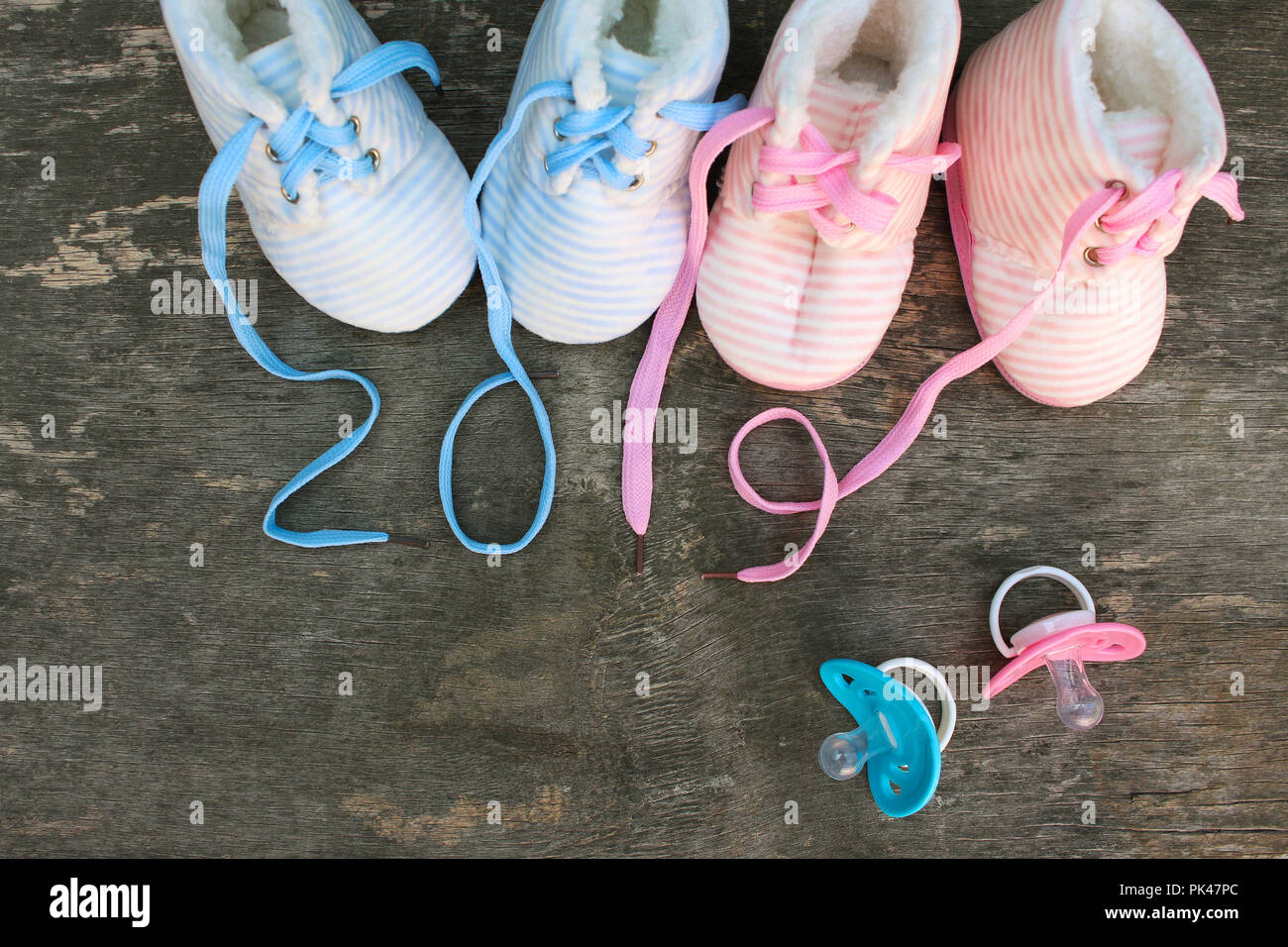 2019 Anno nuovo scritto lacci delle calzature per bambini e ciuccio in legno vecchio sfondo. Vista dall'alto. Lay piatto. Foto Stock