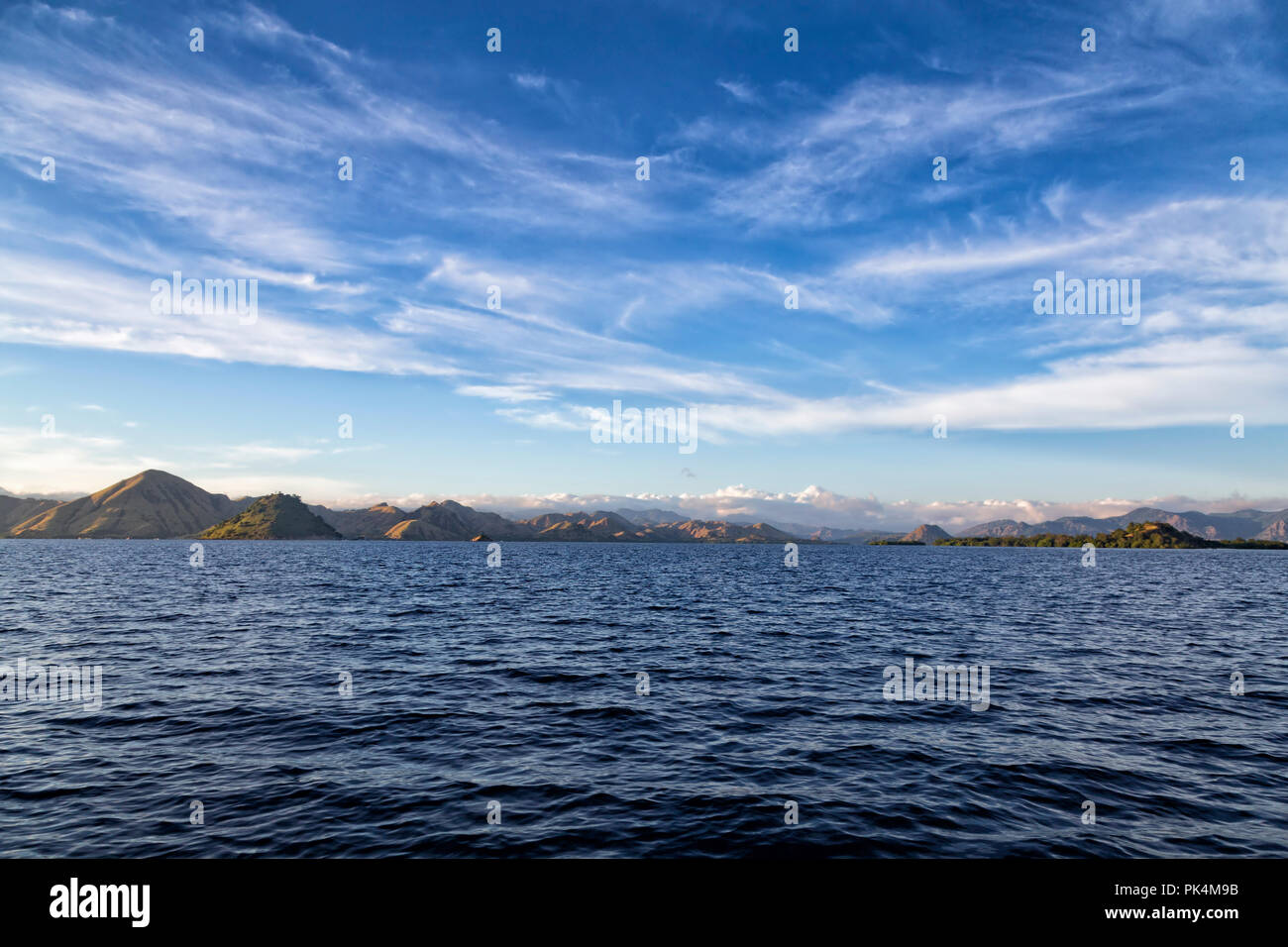 La mattina presto acque blu e il cielo al largo della costa di Rinca isola nel Parco Nazionale di Komodo. Foto Stock