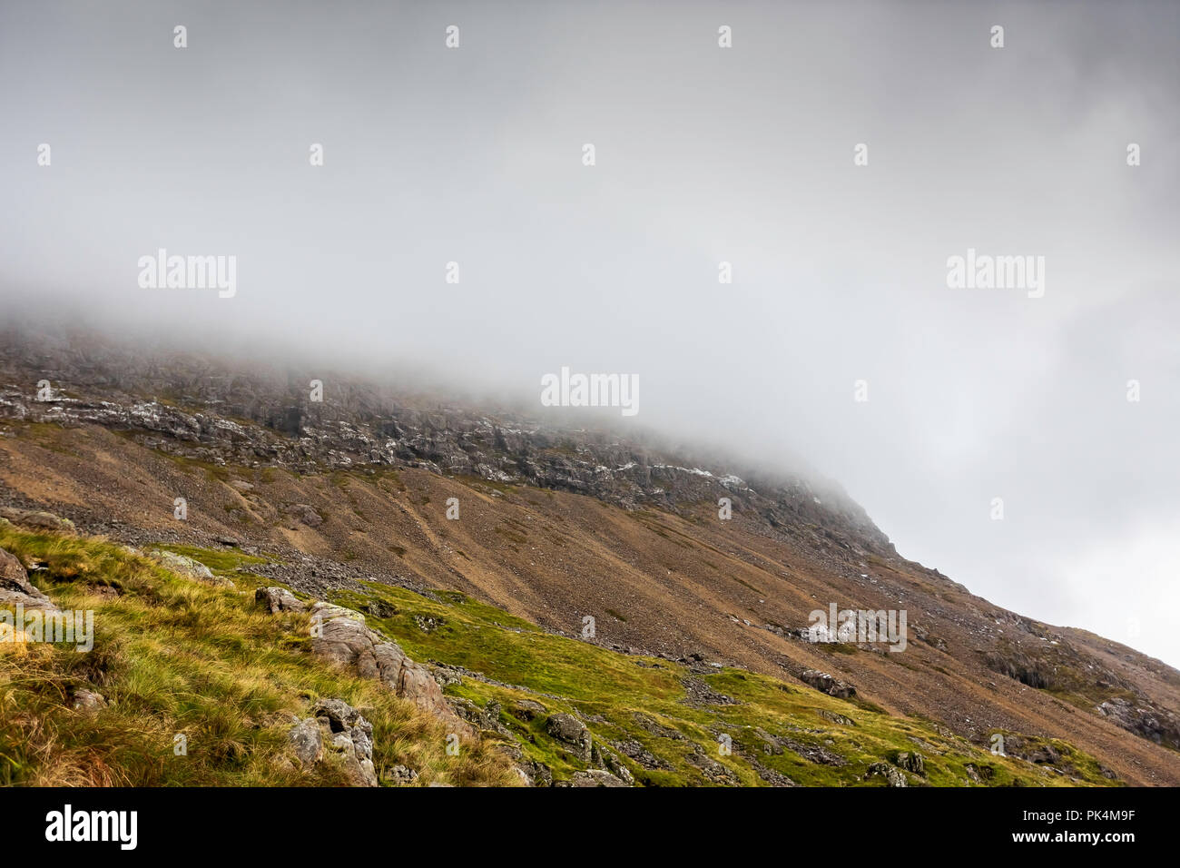 Le splendide vedute guardando fuori attraverso la campagna del Welsh come ho salito Mount Snowdon. La Moody nuvole aggiunto al suggestivo paesaggio. Foto Stock