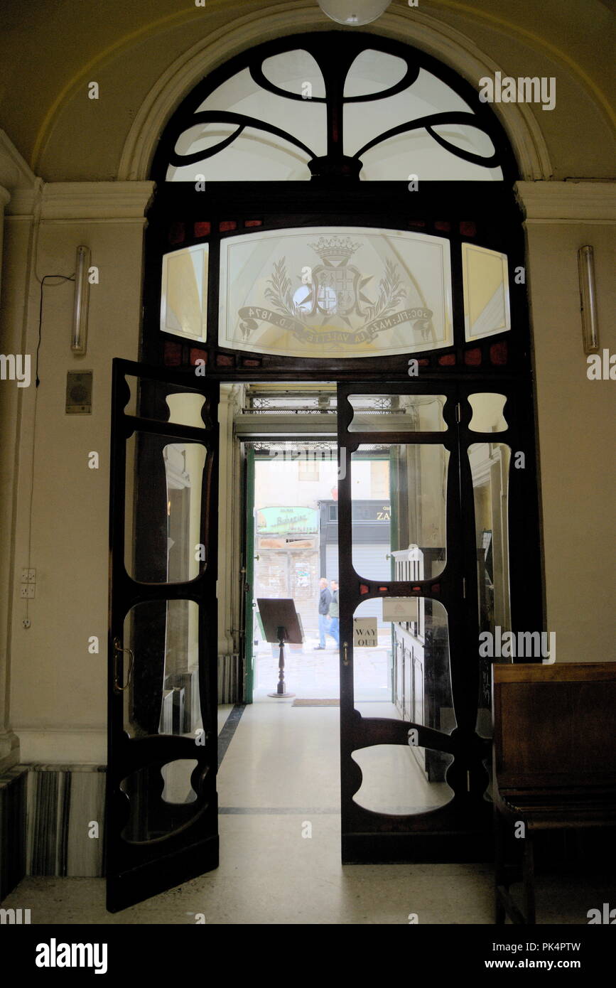 La splendida isola di Malta nel Mediterraneo. Una porta ornata in un bar storico e vecchio stile nella città di Valletta. Foto Stock