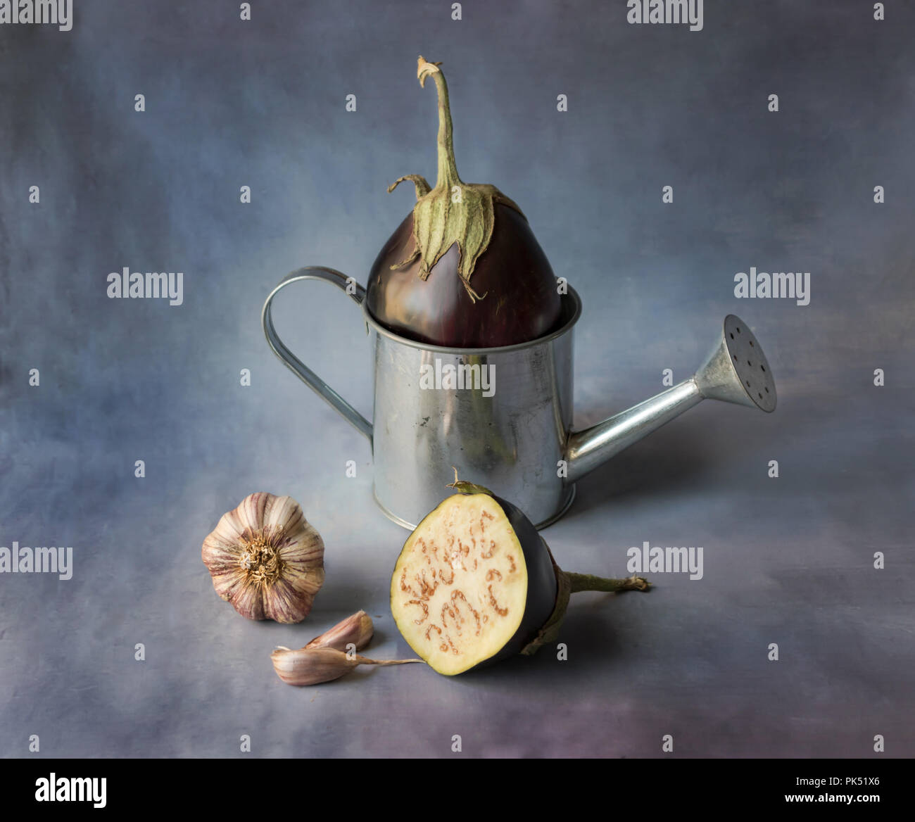 Ancora la vita di melanzane con aglio, ancora la vita di melanzane su uno sfondo blu scuro Foto Stock