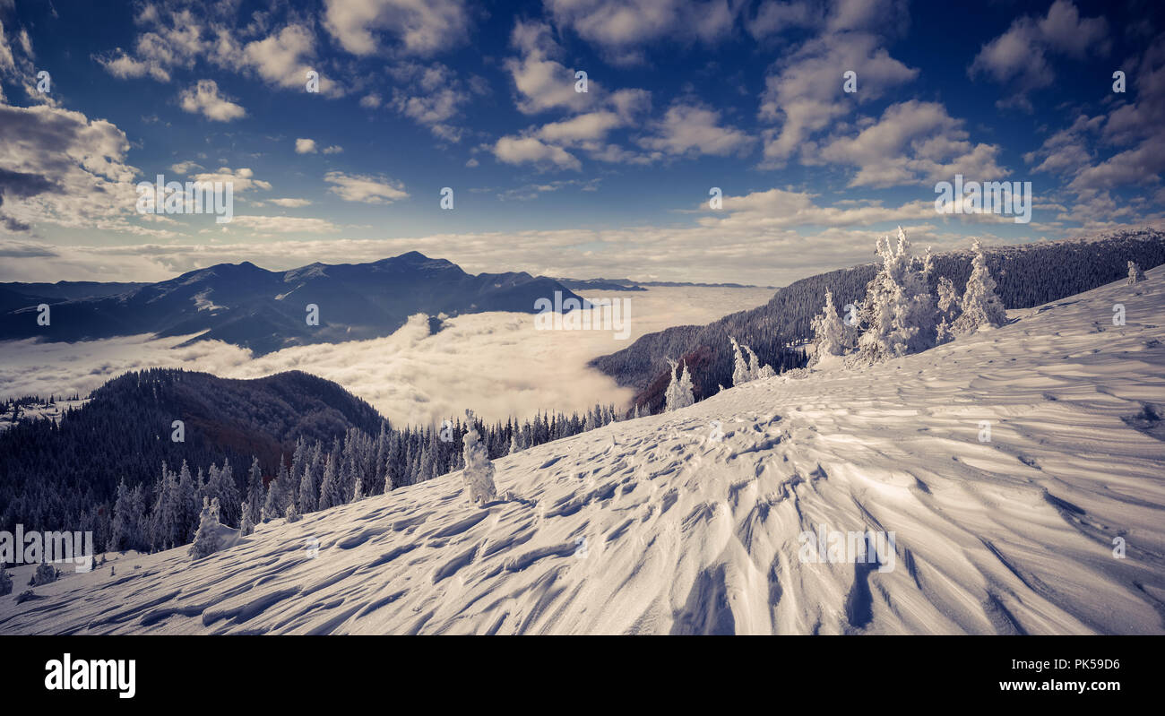 Profondo cielo blu sopra le montagne di nebbia. Drammatica scena invernale stilization. Foto Stock