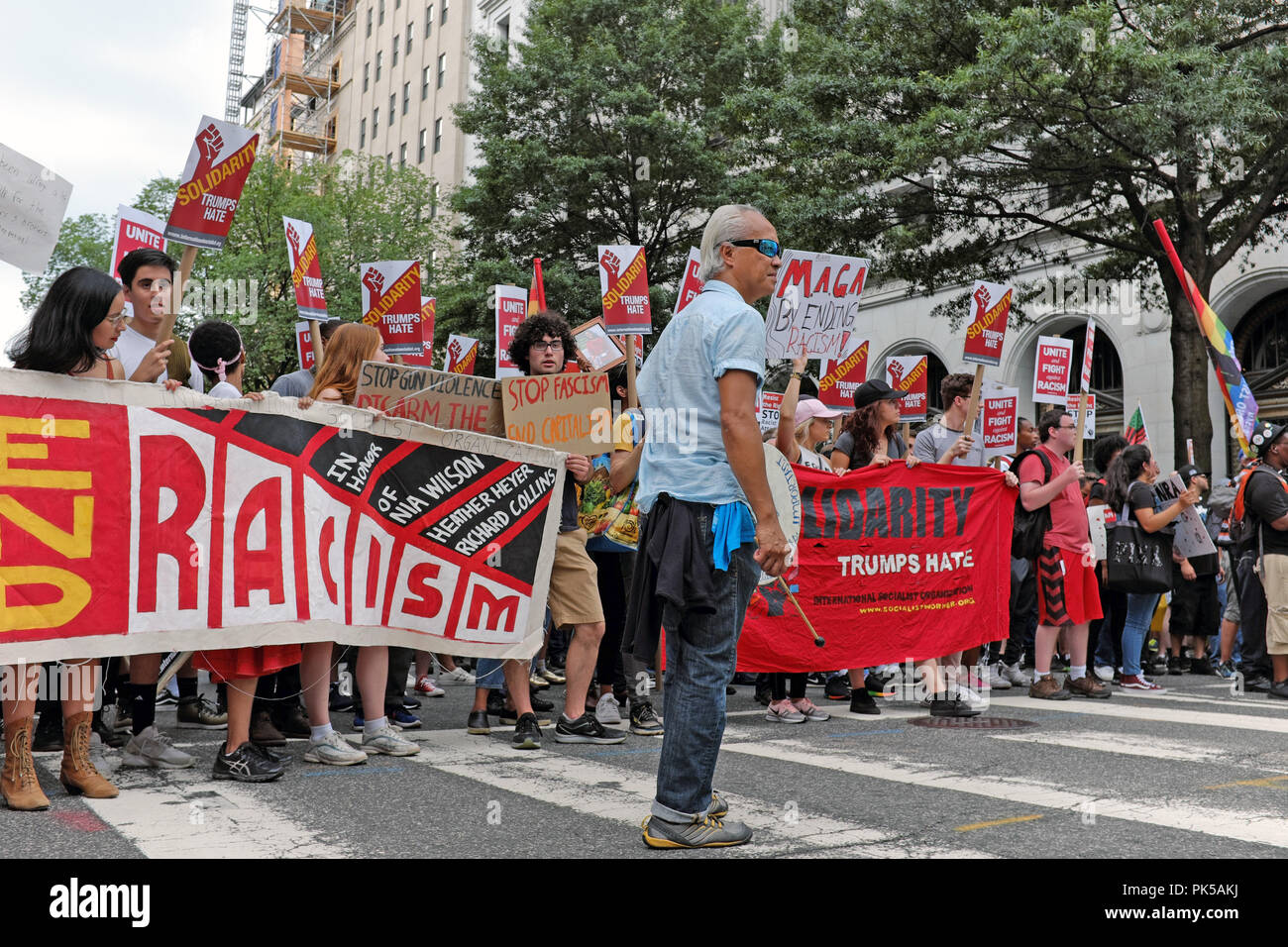 I manifestanti contro la alt-diritto di tenere un banner, 'Fine il razzismo", come entrano Lafayette Park a Washington DC dove il "Regno del diritto 2' è un rally. Foto Stock