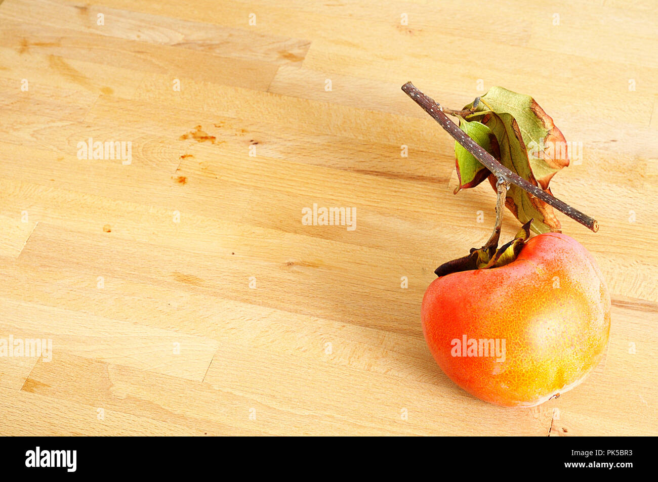 Vista superiore del maturo kaki organico su sfondo di legno. L'alto contenuto di beta-carotene, zeaxantina, insieme con alcuni luteina e alfa-carotene m Foto Stock