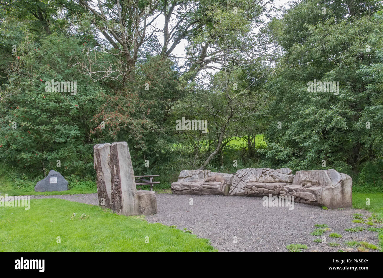 Parkhill legno, Lochwinnoch, Regno Unito - 04 agosto 2018: panca in legno posti a sedere con sculture di piccoli animali che si trovano entro la zona boschiva raffiguranti anima Foto Stock