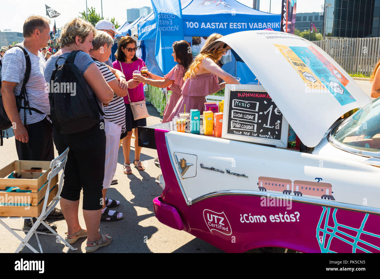 Giovani donne fare e servire cocktail ai clienti in attesa dal retro di un americano degli anni cinquanta, berlina in Kalamaja mercato domenicale, Tallinn, Estonia. Foto Stock