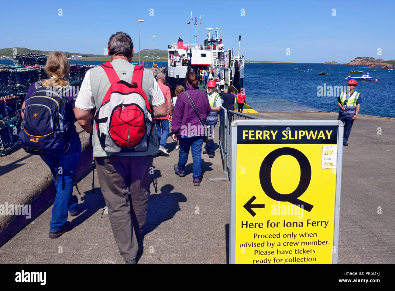 I passeggeri in coda su uno scalo a Fionnphort, Isle of Mull, per il traghetto CalMac per Iona Foto Stock