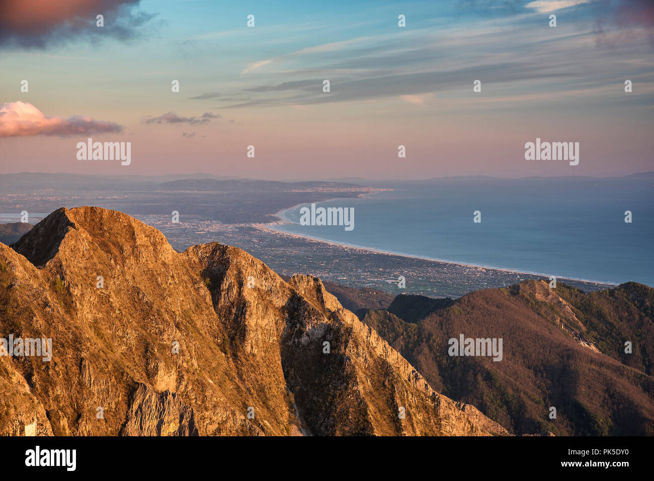 Toscana tramonto dalla cima del monte Borla (1469 metri). In aggiunta al Monte Maggiore (1390 mt) è possibile vedere la Versilia, il lago di Massaciuccoli (estrema sinistra), la macchia di San Rossore e in lontananza le zone abitate di Livorno (sulla costa) e Pisa (all'interno). Sullo sfondo l'isola d'Elba. Foto Stock