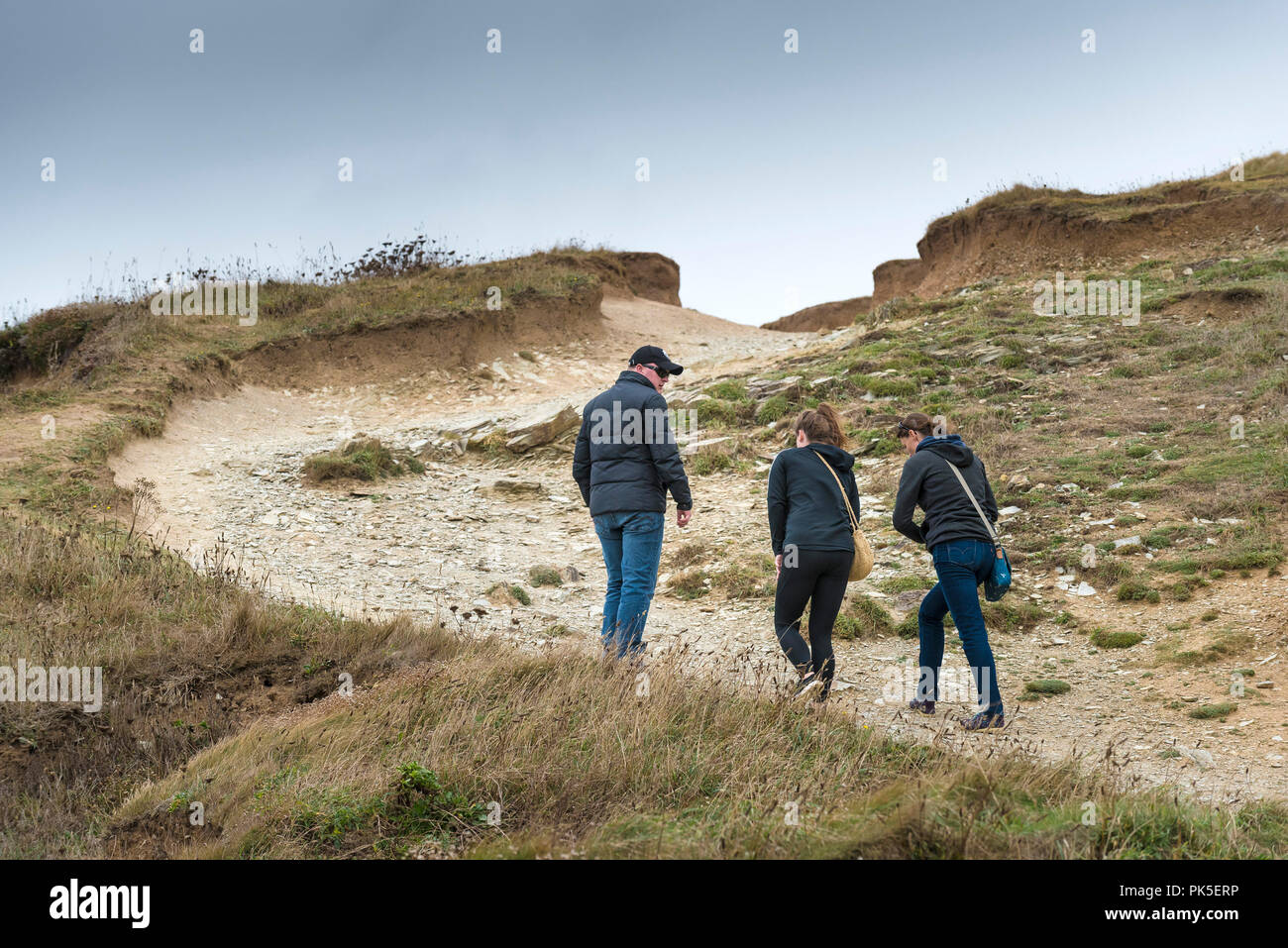 I turisti a piedi su un pesantemente eroso la sezione del South West Coast path sul North Cornwall coast. Foto Stock