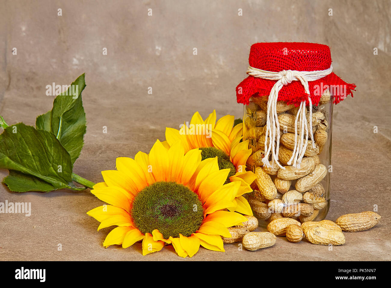 Paese di immagini su sfondo marrone comprendente un vasetto di arachidi e di alcuni con il miele. Girasoli appoggiato accanto a prodotti alimentari. Foto Stock