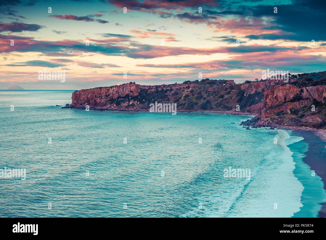 Molla drammatico tramonto sulla spiaggia Torre Conca. Vista del Rais Gerbi cape, mare Mediterraneo, Sicilia, Italia, Europa. Instagram tonificante. Foto Stock