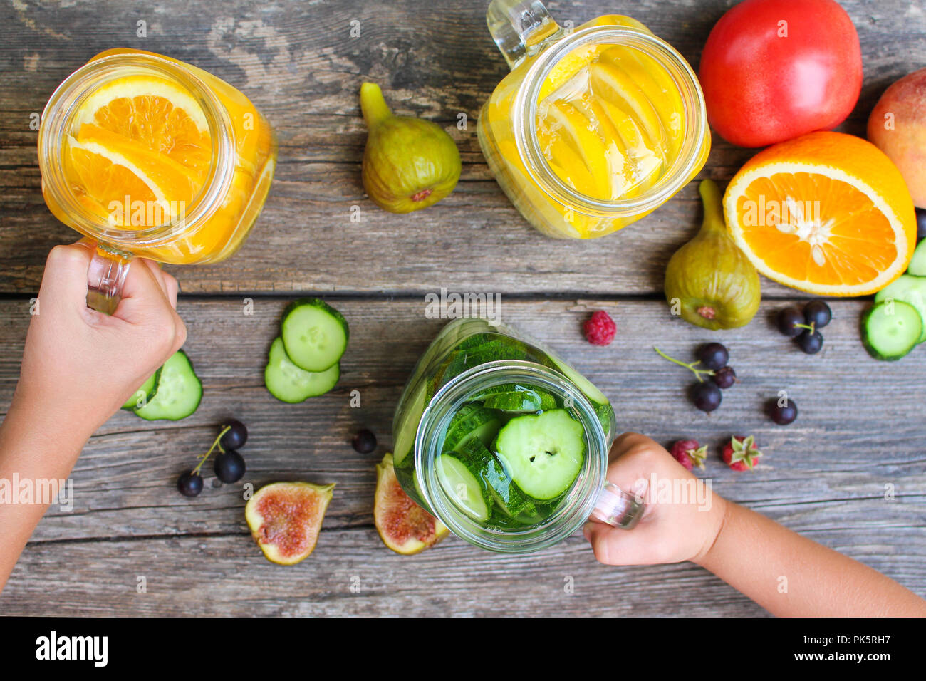 I bambini con le mani in mano prendere bevande a base di frutta e verdura. Foto Stock