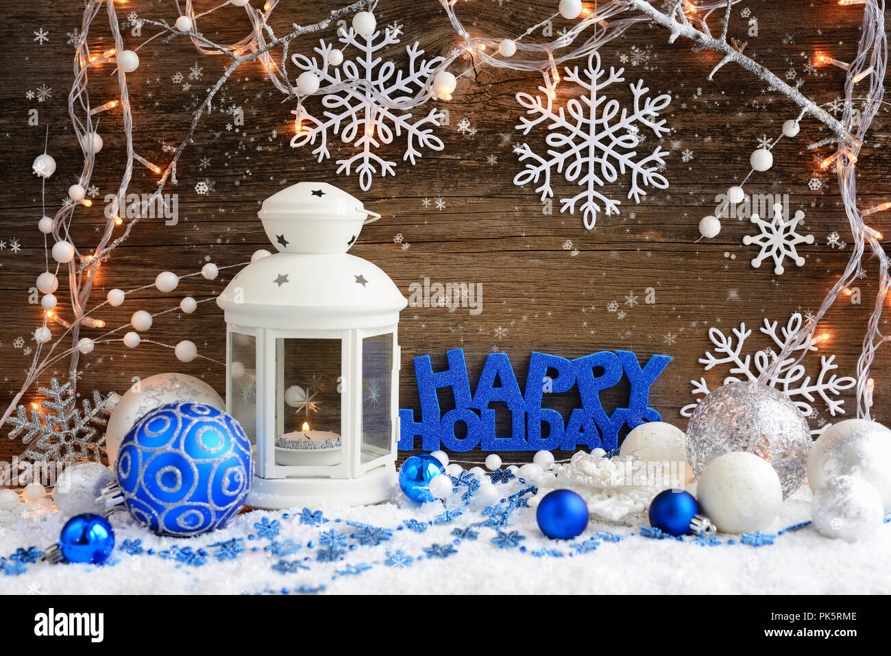 Composizione di natale con la lanterna e la scritta 'Happy Holidays' su sfondo di legno Foto Stock