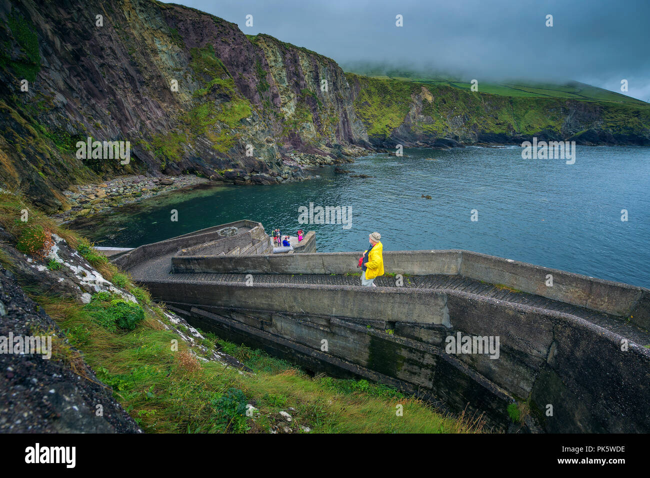 Persone che camminano giù per il Molo di Dunquin in Irlanda Foto Stock