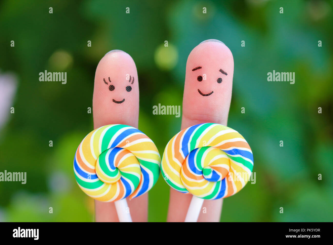 Dita arte di una coppia felice di mangiare la caramella. Foto Stock